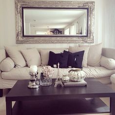 a living room filled with furniture and a large mirror above the coffee table in front of it