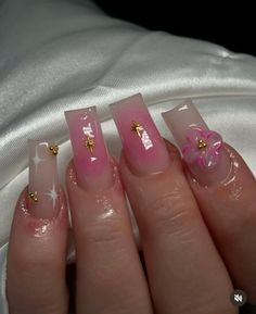 a woman's hand with some pink and gold nail polishes on her nails