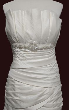 a white wedding dress is displayed on a mannequin