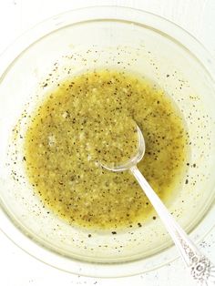 a glass bowl filled with olive dressing and a spoon