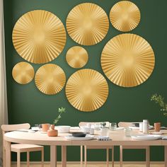 a dining room with green walls and gold plates on the wall