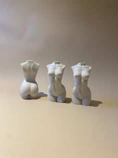 three white ceramic sculptures sitting next to each other