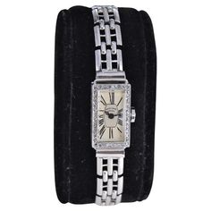 FACTORY / HOUSE: Bailey, Banks & Biddle STYLE / REFERENCE: Art Deco Dress Watch METAL / MATERIAL: 18Kt. White Gold with Gold Filled Matching Bracelet CIRCA / YEAR: 1930's DIMENSIONS / SIZE: 24 Length X 12mm Width MOVEMENT / CALIBER: Manual Winding / 17 Jewels DIAL / HANDS: Silvered with Roman Numerals / Blued Steel Hands ATTACHMENT / LENGTH: Gold Filled Art Deco Bracelet 9 mm Adjustable 20cm length or 8 Inches. WARRANTY: 18 months on the movement This unique ladies watch from the 1930's in entir Luxury Art Deco Rectangular Watches, Factory House, Ladies Dress Watches, Art Deco Watch, Deco Dress, Art Deco Dress, Reference Art, Art Deco Lady, Style Reference