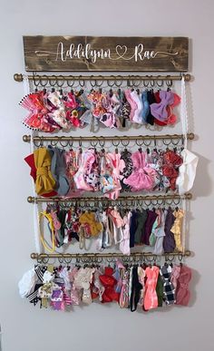 a rack with many different types of baby clothes hanging on it's sides,