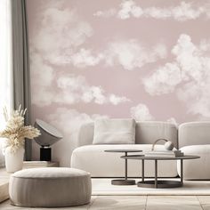 a living room with pink clouds painted on the wall and white furniture in the corner