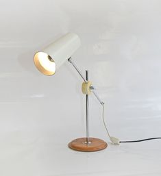 a white desk lamp with a wooden base on a white background, the light is turned off