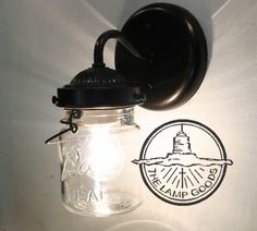 a light that is on the wall next to a glass jar with a lid and handle