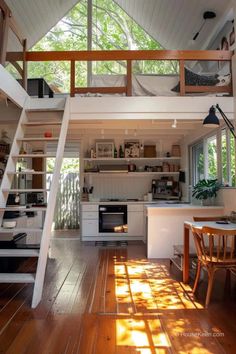 an open loft with stairs leading up to the kitchen