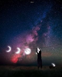 a person holding onto a string with the moon and stars in the sky above them