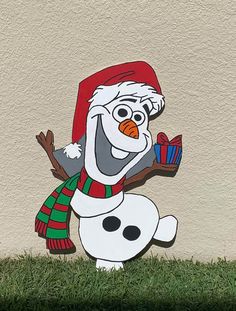 a snowman with a red hat and scarf holding a gift box in his hand