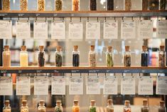 spices and herbs displayed on glass shelves in a store or office building with price tags