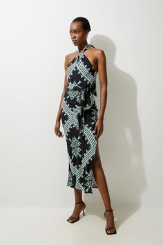 Bring In The Summer With Our Maxi Dress, With A Fit That Flatters The Curves, And A Statement Geometric Print. The Twisted Halter Neckline Elevates The Formality, While The Thigh High Leg Split Makes For A Statement Piece. It Is Adorned With Detailed, In-House Designed Print Work, And Can Easily Be Styled With A Pair Of Sandals Or Heels. Geo Printed Morocain Woven Maxi Dress High Quality Morocain Fabric Comfortable Figure Skimming Fit Unique Geometric Print Twisted Halter Neckline Thigh High Leg Elegant Patterned Printed Midi Dress, Elegant Printed Patterned Midi Dress, Elegant Patterned Beach Dresses, Elegant Printed Viscose Maxi Dress, Elegant Sleeveless Patterned Dress, Petite Wedding Guest Dresses, Plus Size Workwear, Latest Maxi Dresses, Summer Bridesmaid Dresses