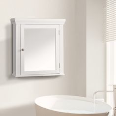 a white bath tub sitting next to a wall mounted medicine cabinet in a bathroom under a window