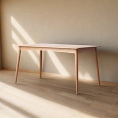 a wooden table sitting on top of a hard wood floor in front of a window