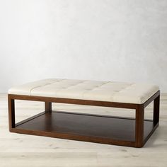 a white leather bench sitting on top of a hard wood floor