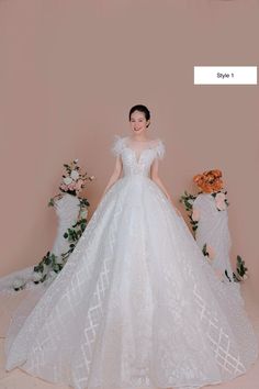 a woman in a white wedding dress standing next to flowers