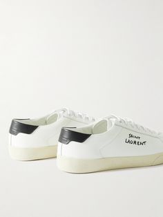 SAINT LAURENT's 'SL/06' sneakers pay homage to classic tennis styles. Made with leather uppers and rubber soles, they're treated to soften the hide. The brand's moniker is embroidered at the sides and subtly debossed at the heel tabs. Saint Laurent Court Classic, Saint Laurent Collection, Off White Shoes, Embroidered Leather, Saint Laurent Shoes, Latest Sneakers, Perforated Leather, Classic Logo, Classic Sneakers