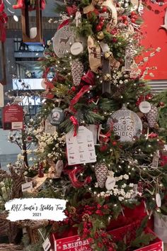 a christmas tree is decorated with red and silver ornaments, bows, pine cones, and other holiday decorations