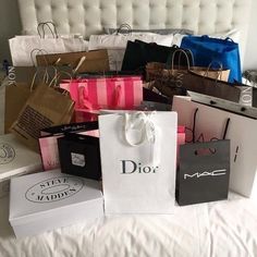 many bags are stacked on top of each other with the word dior printed on them