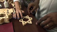 two people playing with wooden toys on a table