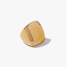 a gold ring on a white surface with the top half cut out to show it's rounded shape