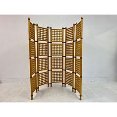 a wooden room divider sitting on top of a white floor