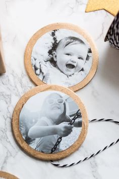 two wooden coasters with photos on them sitting on a marble table next to a star