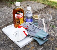 an assortment of household cleaning products on a tray outside in the sun, including gloves and cleaner's mitts