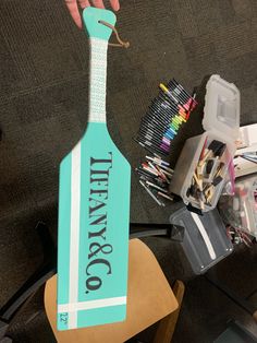 there is a wooden paddle with the name tiffany's co on it and many other craft supplies