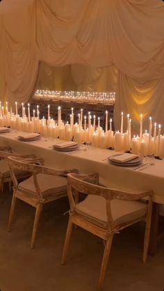 a long table with many lit candles on it in a banquet hall or function room