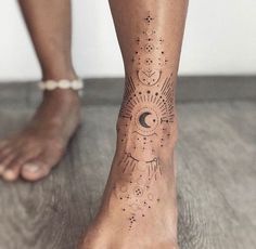 a woman's foot with a sun and moon tattoo on it