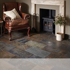 a living room with a chair, fireplace and pictures on the wall in it's corner