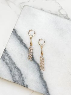 Add a touch of glam to your look with our Gold Huggie Hoop Crystal Drop Earrings. These elegant earrings feature a glitzy dangle design that will catch the light and add sparkle to any outfit. Perfect for a night out or a special occasion, these earrings are sure to make a statement. 0.75"L Lead & Nickel Compliant Party Dangle Huggie Earrings, Party Huggie Dangle Earrings, Small Hoop Earrings With Sparkling Stones For Party, Sparkling Stones Small Hoop Earrings For Party, Sparkling Stones Drop Earrings, Glamorous Small Hoop Cubic Zirconia Earrings, Trendy Dangle Hoop Earrings For Wedding, Sparkling Dangle Hoop Earrings With Cubic Zirconia, Sparkling Cubic Zirconia Dangle Hoop Earrings