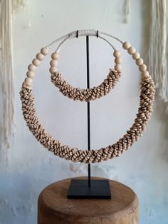 Handmade ceremonial Papua traditional Ornament from Indonesia. Made of white Shells . This Necklace is used in Papua for special rituals or ceremonies. Also is used as a payment between tribes. This beautiful piece is a very unique and powerful object in the Balinese culture. Size: L38, H38 high stand 47cm 0.8kg Perfect for elegant parties and all kind of Carnivals ! It can be wearied or used as a Decoration. You can buy with black metal stand You can buy without stand, you can hang it on the wa Bohemian Necklaces With Wooden Beads For Puja, White Artisan Jewelry For Festivals, Artisan White Jewelry For Festivals, Natural Round Beaded Jewelry For Festivals, Bohemian Wooden Beads Jewelry For Puja, Traditional Handwoven Natural Jewelry, Artisan White Necklaces For Festivals, Traditional Handwoven Natural Color Jewelry, White Adjustable Necklaces For Rituals