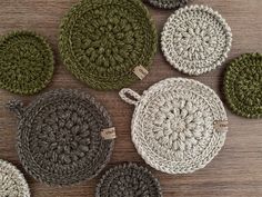 several crocheted round baskets sitting on top of a wooden table