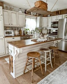 a kitchen with two stools in front of the counter and an island that has three stools on it