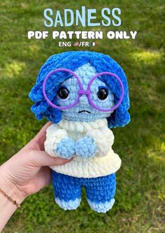 a small crocheted doll with glasses on it's head