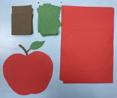 an apple cut out from construction paper next to a piece of cardboard