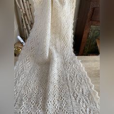 a white crocheted blanket sitting on top of a wooden chair