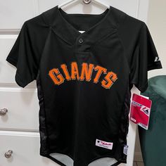 a san francisco giants baseball jersey hanging on a dresser