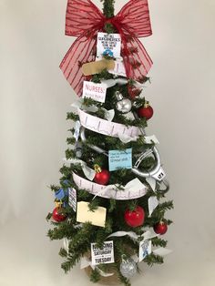 a small christmas tree decorated with red ribbon