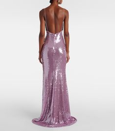 a woman in a purple sequin gown looking back at the camera with her back turned