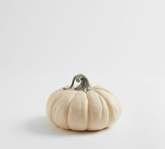 a small white pumpkin sitting on top of a table