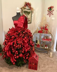 a christmas tree with red ornaments and bows on it in a room decorated for the holiday season