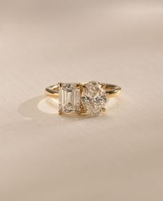 three stone diamond ring on white surface with light colored backround and shadow effect