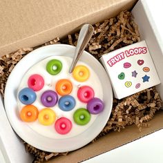 an open box containing a plate with doughnuts on it and a spoon in the bowl