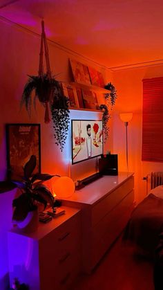 a bed room with a neatly made bed and some plants on the dresser next to it