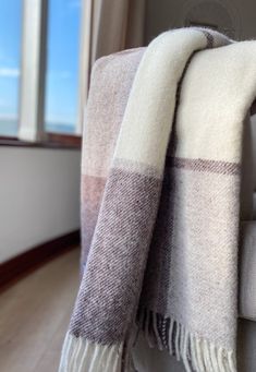 a plaid blanket draped over a couch next to a window