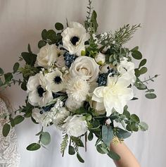 a bouquet of white flowers is being held by two women