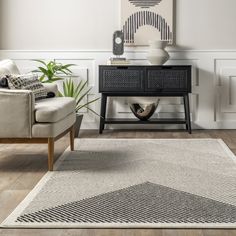 a living room with a couch, chair and rug on the floor in front of a painting